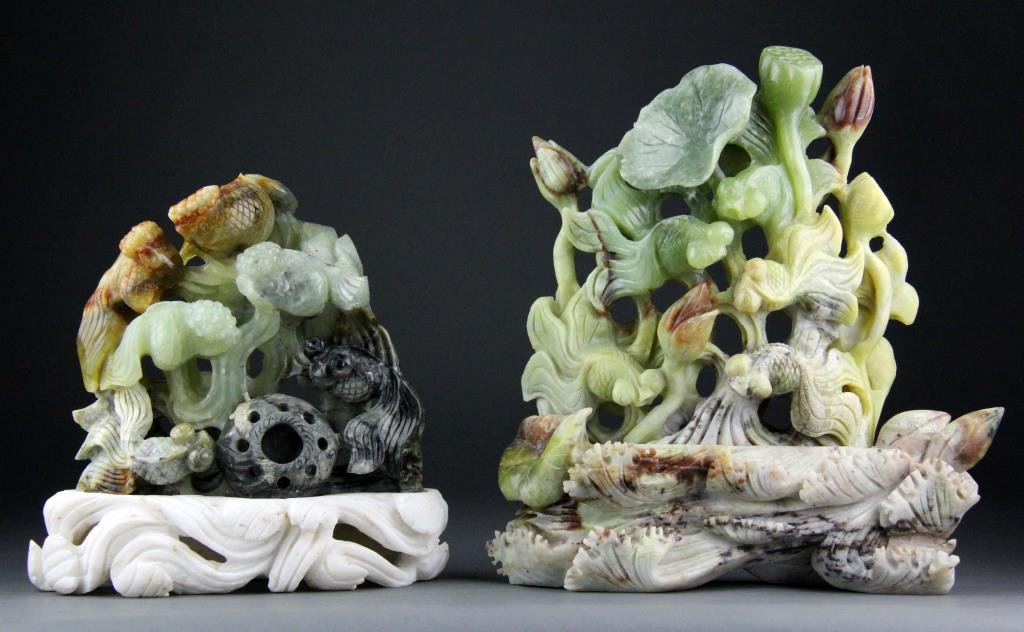 (2) Chinese Jade Carvings of Popeyed Goldfish and Waves: Two finely carved light to dark green jades to depict popeyed goldfish and waves on white carved bases, 8.25" H x 10" L including base, circa 20th century, good condition.