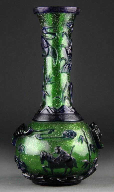 Chinese Peking Glass Vase - Cobalt/Green: Narrow-necked vase with bulbous body having cobalt blue overlay over green ground with gold flecks, Greek Key design on rim and shoulder, body carved bats, monkeys riding horses and elephants with dee