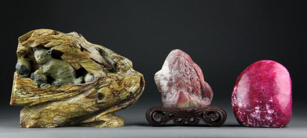 (3) Chinese Jade and Stone Carvings: To include a finely carved jade cat, a carved soapstone boulder with elder and deer on one side and figures and trees on reverse on pierced wood stand, and a highly polished rasberry boulder, largest 
