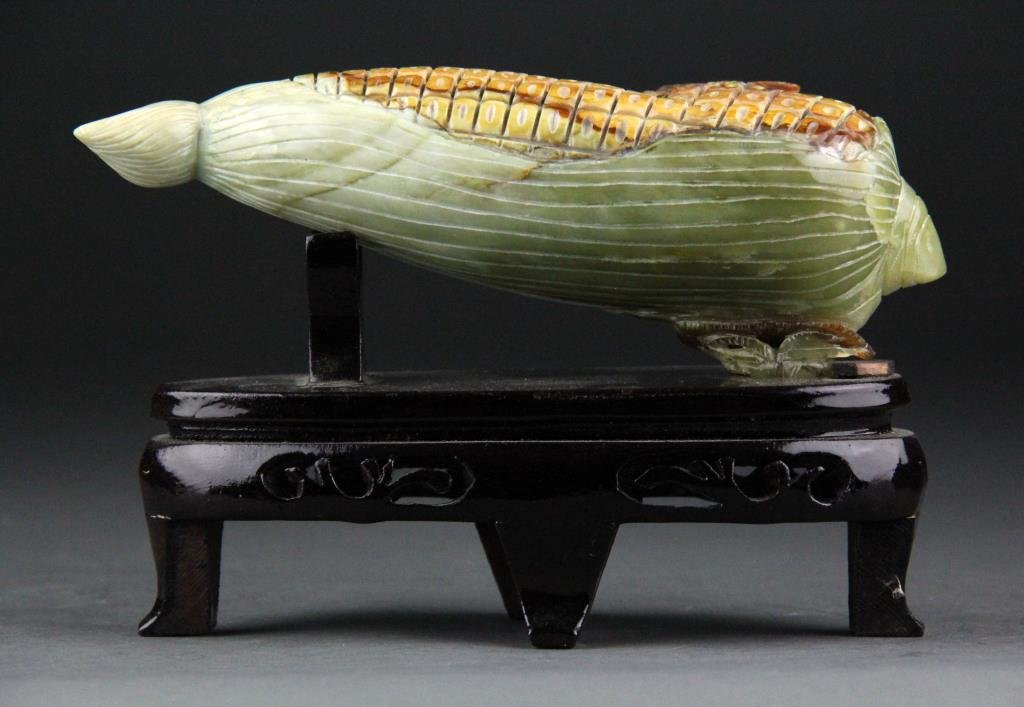 Chinese Jade Carving of Corn Cob with Spider: Finely carved green to yellow jade depicting a corn cob with spider along with wooden reticulated stand, 4.75" H x 7.25" L including base, circa 20th century, good condition.