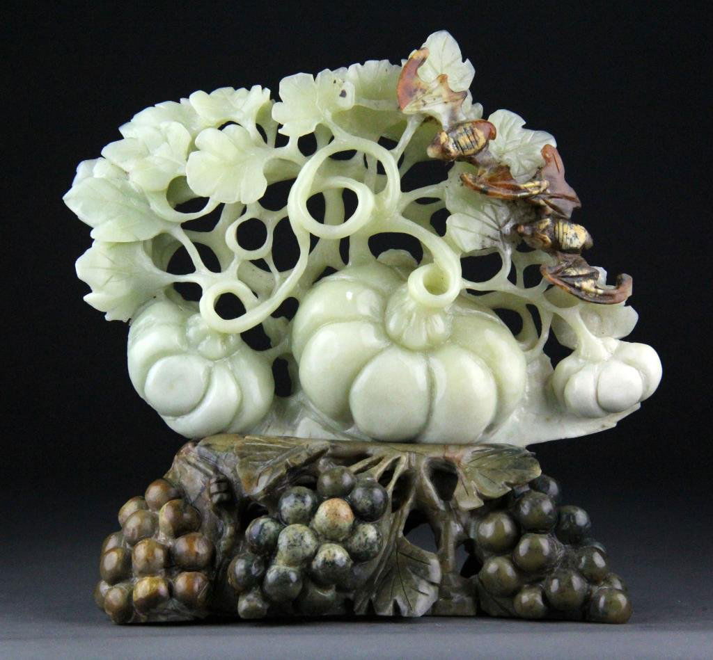Chinese Jade Carving of Pumpkins & Grapes: Finely carved light celedon jade depicting pumkins and bats raised on carved brown jade base, 7.5" H x 7.25" L including base, circa 20th century, minor chip to grape leaf otherwise good overall condi