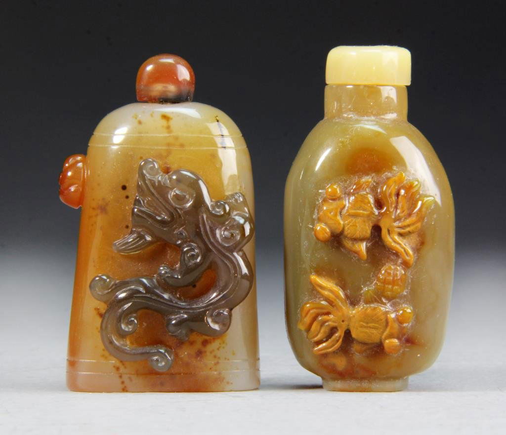 (2) Agate Snuff Bottles: Appliqued dragon design with protruding flower on side, double lines carved along top and bottom, second with coy fish overlay, tallest 2.625"H. Condition: good, both with stoppers.