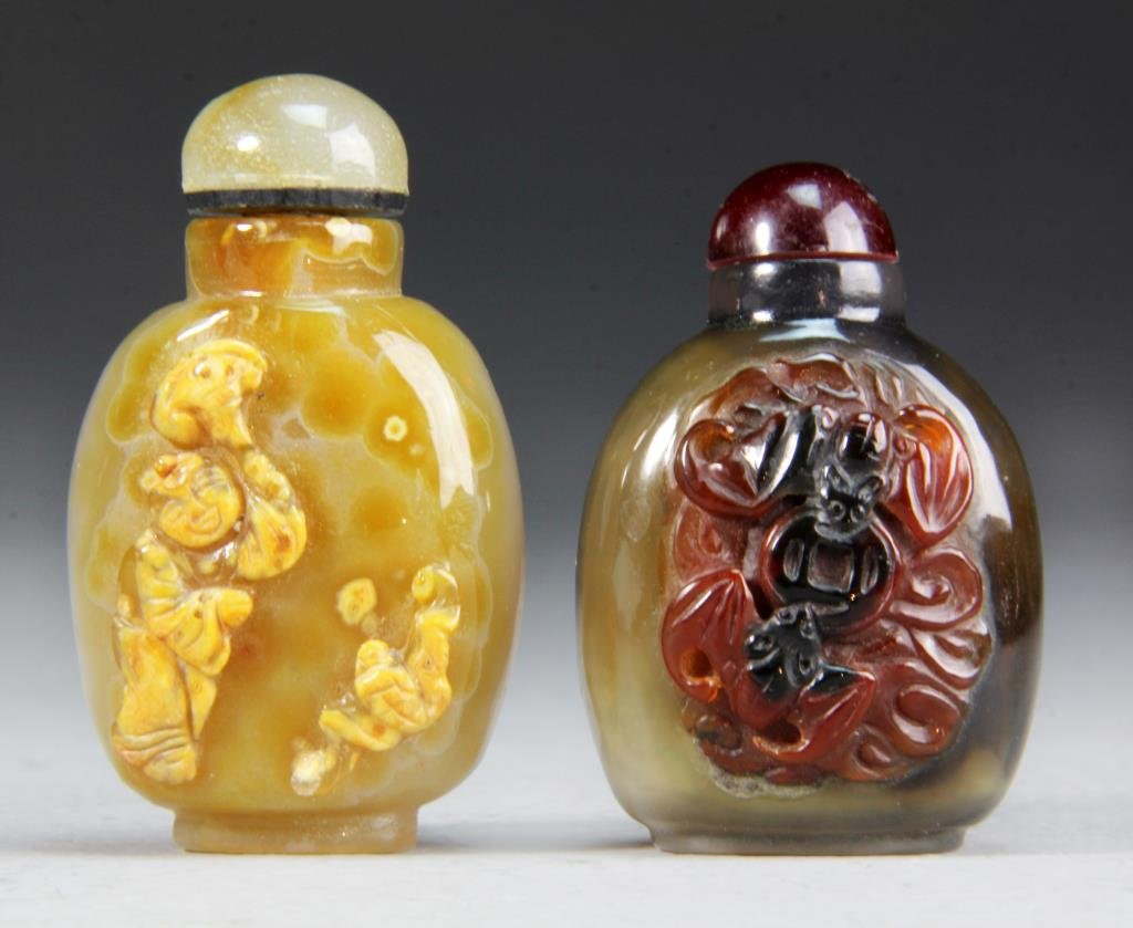 (2) Pcs Chinese Agate Snuff Bottles: To inlcude two finely carved and polished snuff bottles, one depciting bats contesting a coin, the other a bat and a figure with a fan, largest measures 2.5"H.