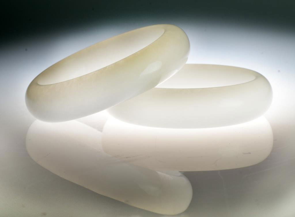 Pr. Chinese Carved White Jade Bangles: Both in mutton fat color uncarved exhibiting a fine polish in good color, 3.375" & 3.25"D. Private collection Dearborn, Michigan.