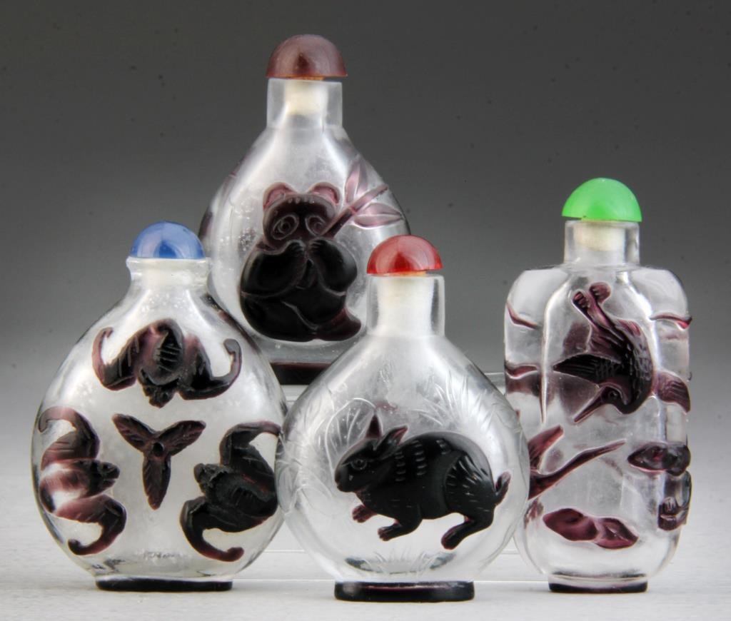 (4) Pcs Chinese Peking Glass Snuff Bottles: Finely overlayed with rabbits, bats, cranes and pandas, respectively, two incised with landscape design, tallest is 2.875"H. Condition: good, all complete with stoppers.