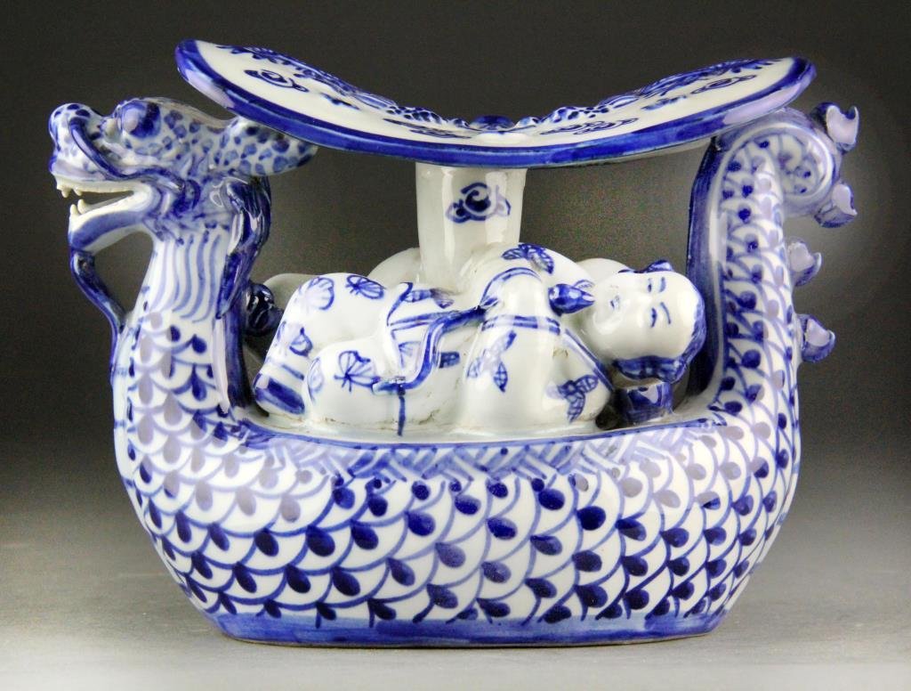 Chinese Porcelain Blue and White Headrest: In the form of a dragon-ship, male and female sleeping figures beneath headrest decoated with ruyi clouds and two dragons, six character marks impressed in bottom, 6" H x 8.5" L, circa 20th century, g