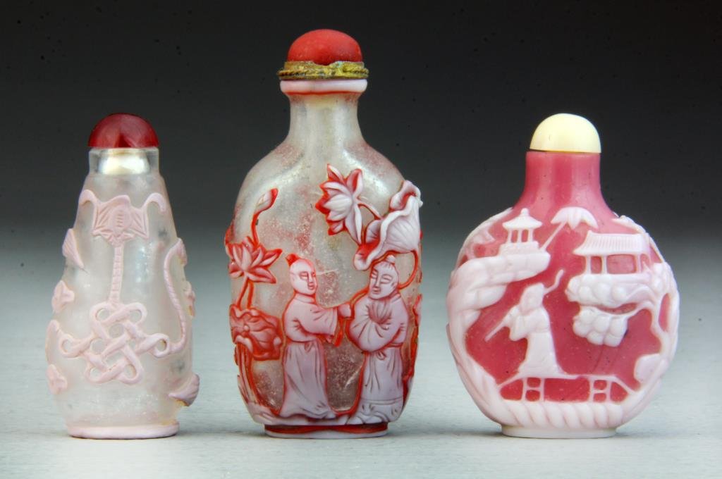 (3) Pcs Chinese Peking Glass Snuff Bottles: All having finely carved decoration depicting Shou symbols, figures with bats amongst trees and lotus blossoms, and figures within a landscape, largest measures 3.25"H.