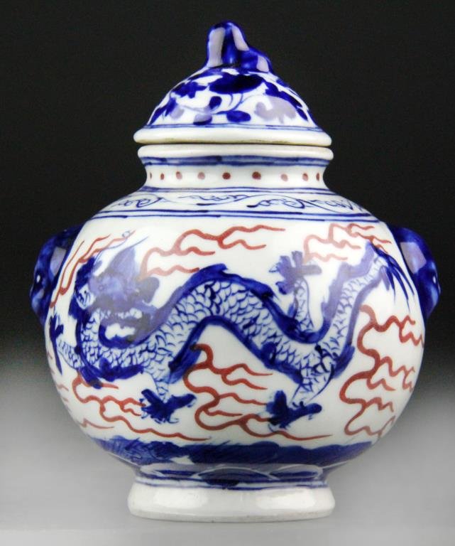 Chinese Blue/White/Red Porcelain Covered Jar: Bulbous blue and white porcelain covered jar having blue dragons and red ruyi clouds, top is has tendril decoration with dog finial, two faux handles, underglazed blue leaf mark on bottom, 4.5" H x 3.