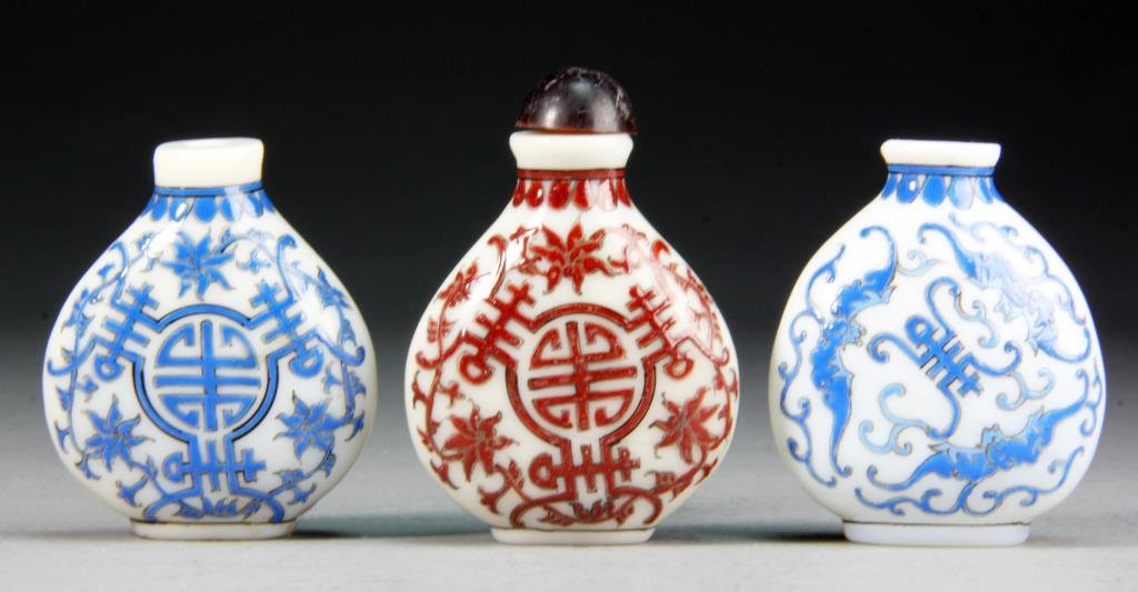 (3) Peking Glass Snuff Bottles: Finely painted Shou to depict lotus flowers, scrolling tendrils and bats, base bearing 3 character mark under glaze, tallest is 3.5 "H. Condition: two lacking stoppers.