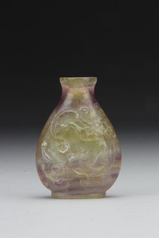 Chinese Carved Rock Crystal Snuff Bottle: Finely carved to depict bat and lion, polished to show natural purple properties of crystal, lacks stopper, 2.4"H. From the collection of David Bell who worked for an Italian steel company in China du