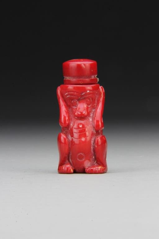 Chinese Carved Coral Snuff Bottle: Finely carved to depict "hear no evil" crouching monkey, having smooth polished surface, complete with matching stopper and spoon, 2.3"H. From the collection of David Bell who worked for an Italian st