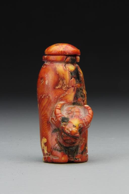 Chinese Carved Coral Snuff Bottle: Finely carved to depict head and feet of ox at base, having surface imperfections due to aging, complete with matching stopper, 2.75"H. From the collection of David Bell who worked for an Italian stee