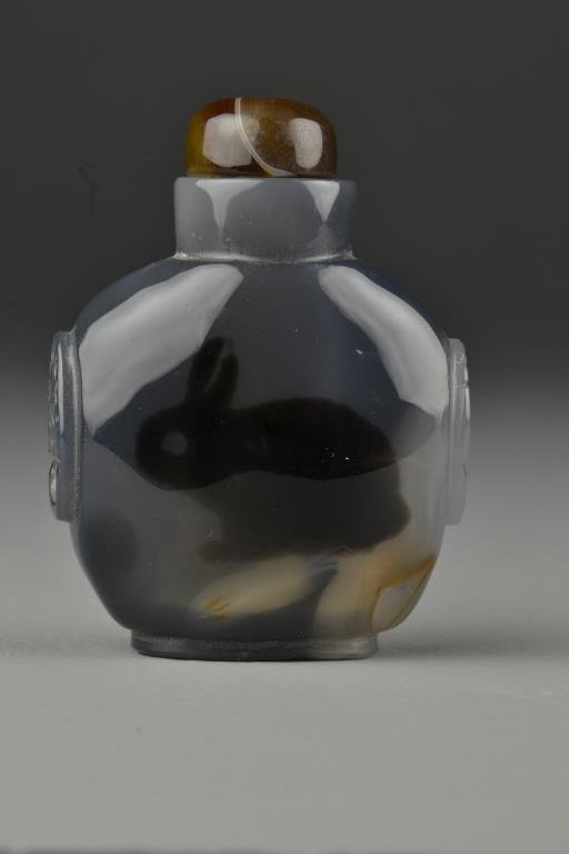 Chinese Carved Agate Snuff Bottle: Finely polished with carved beast head handles, dyed to depict rabbit, complete with agate stopper, 3.4"H. From the collection of David Bell who worked for an Italian steel company in China during the