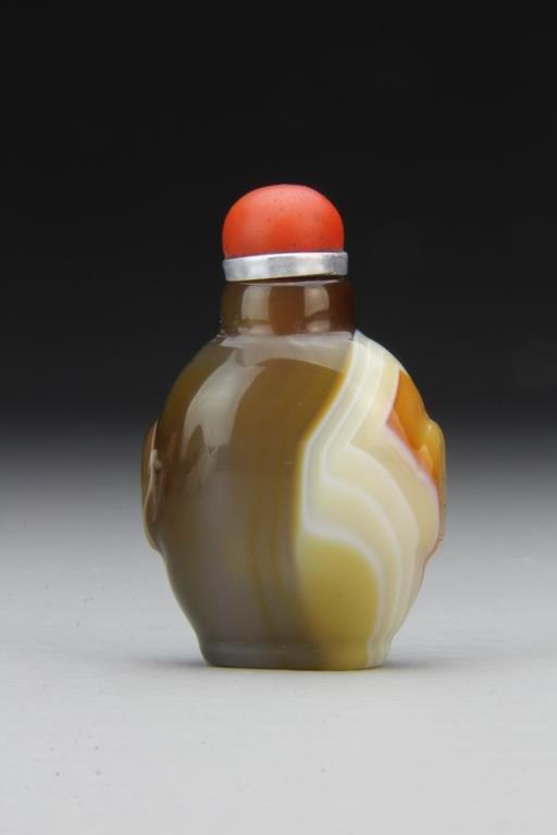 Chinese Carved Agate Snuff Bottle: Finely polished and carved to show natural properties of stone, having beast head handles, complete with stopper, 2.6"H. From the collection of David Bell who worked for an Italian steel company in Ch