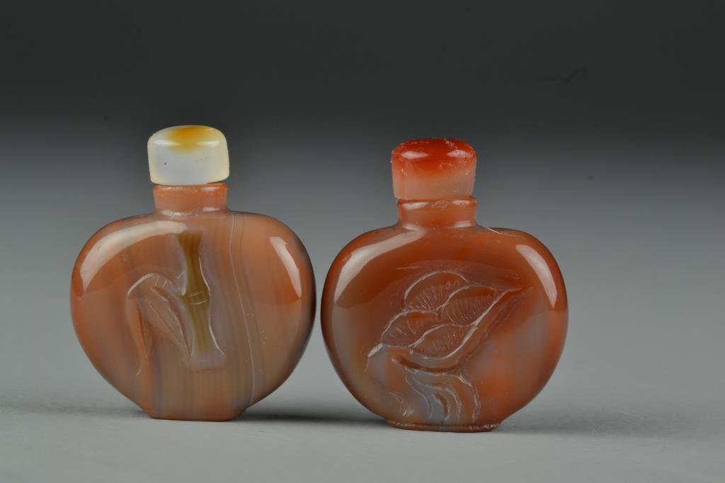 (2) Chinese Carved Agate Snuff Bottles: Very finely polished to show natural properties of the stone, carved to depict plants, complete with stoppers, 1.9"H. From the collection of David Bell who worked for an Italian steel company in China