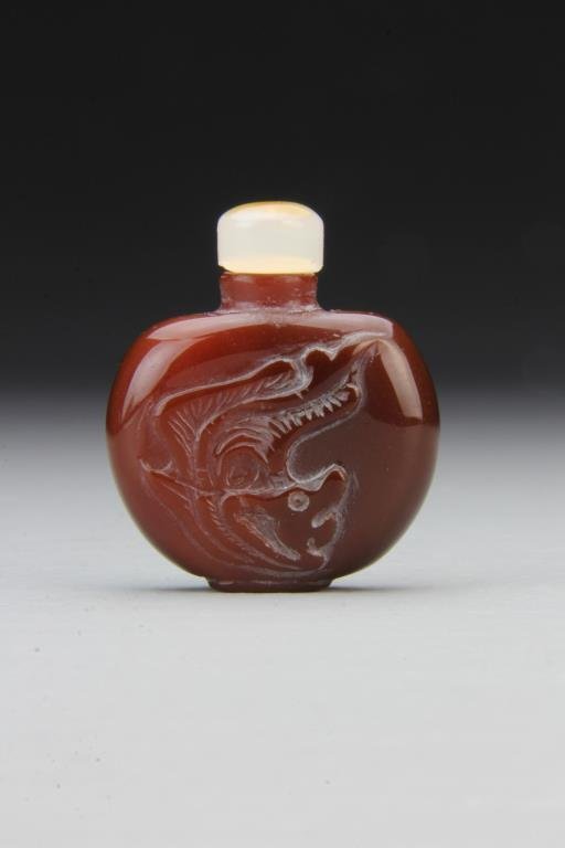 Chinese Carved Agate Snuff Bottle: Finely polished and carved to depict mythological beast, having detached stone stopper, 2"H. From the collection of David Bell who worked for an Italian steel company in China during the 1980's.