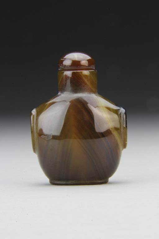 Chinese Carved Agate Snuff Bottle: Finely polished to show natural properties of the stone, carved with beast head handles, complete with matching stopper, 2.4"H. From the collection of David Bell who worked for an Italian steel compan