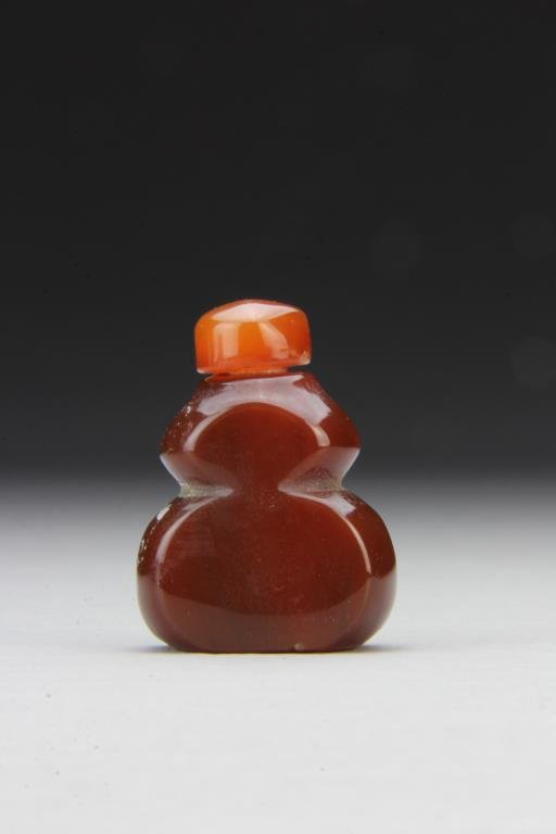 Chinese Carved Agate Snuff Bottle: Having gourd form, finely polished and carved to show natural properties of the stone, having matching detached stopper, 1.75"H. From the collection of David Bell who worked for an Italian steel compa