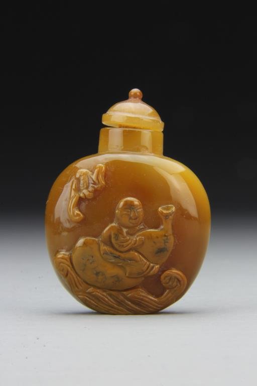 Chinese Carved Agate Snuff Bottle: Finely polished and carved to depict figure atop gourd with bat, complete with matching stopper, 2.5"H. From the collection of David Bell who worked for an Italian steel company in China during the 19