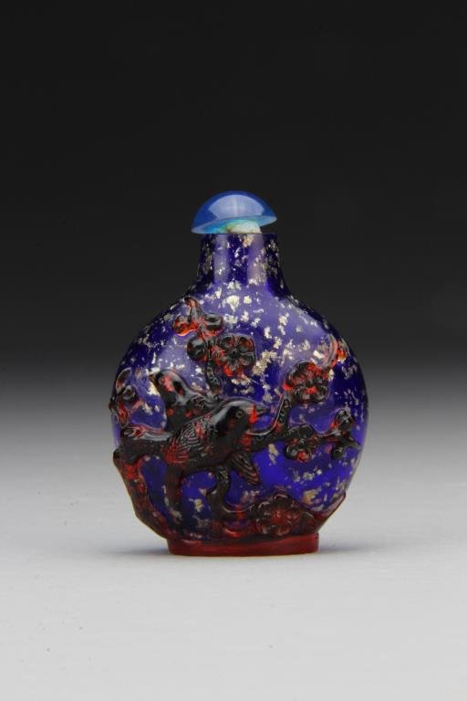 Chinese Peking Glass Snuff Bottle: Blue and gold flecked glass with overlay depicting birds among flowering branches, complete with stopper, 2.3"H. From the collection of David Bell who worked for an Italian steel company in China duri