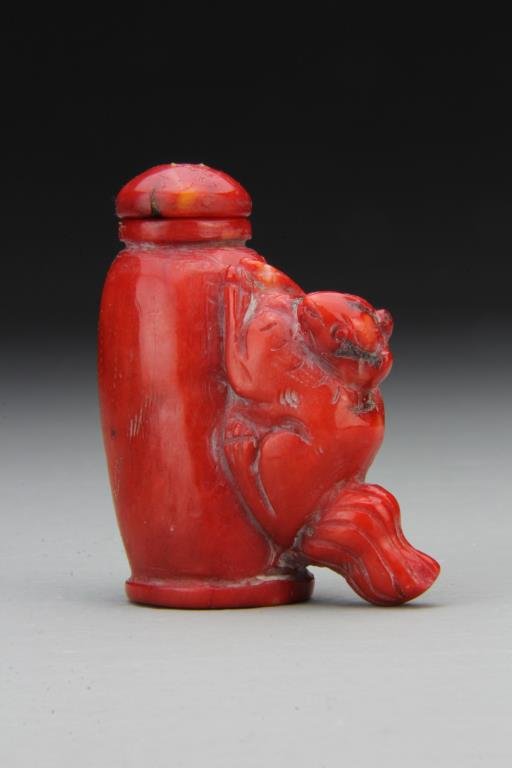 Chinese Carved Coral Snuff Bottle: Finely carved coral bottle with protruding form of squirrel, some surface imperfections on reverse, complete with matching stopper, 2.75"H. From the collection of David Bell who worked for an Italian 