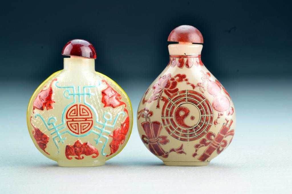 (2) Chinese Peking Glass Snuff Bottles: One painted to depict bats and symbols, the other depicting various antiques surrounding a yin-yang symbol with base bearing four character mark in iron red, tallest is 3.2"H. From the collection of D