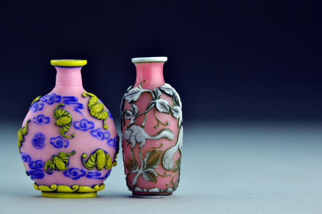 (2) Chinese Peking Glass Snuff Bottles: Each having dual-colored overlay, one depicting squirrels and grapes, the other depicting bats, symbols and ruyi clouds, tallest is 2.75"H. From the collection of David Bell who worked for an Italian 