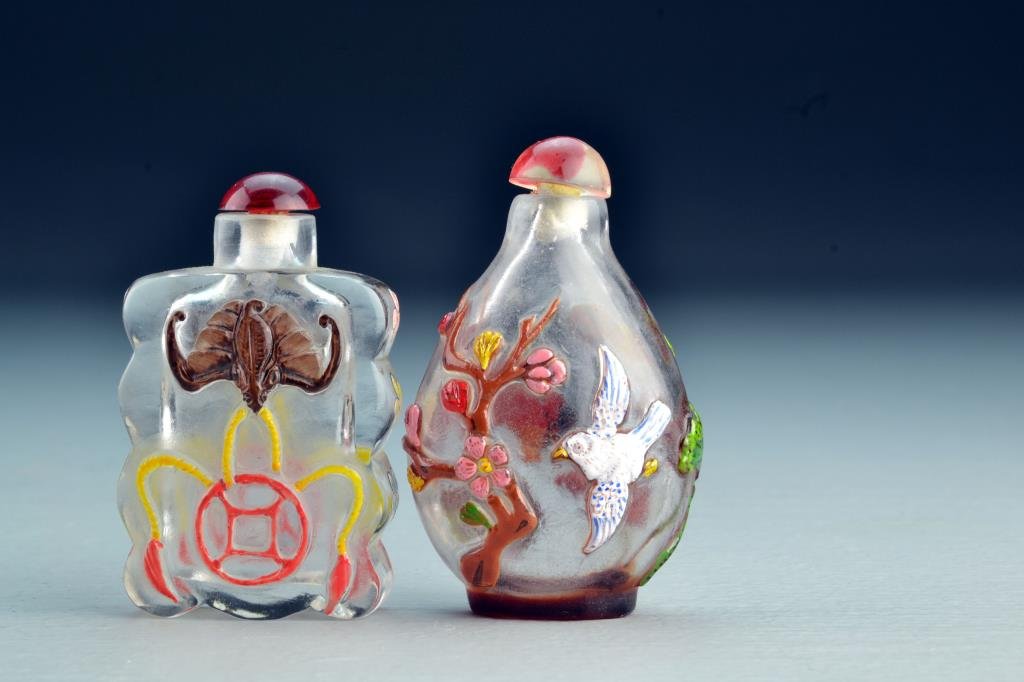 (2) Chinese Peking Glass Snuff Bottles: Each clear glass with multi-colored overlay, one depicting bats and flowers, other depicting fish and lotus in water with bird and flowering tree on reverse side, tallest is 2.8"H. From the collection