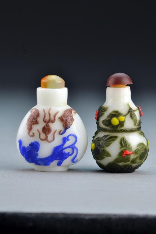 (2) Chinese Peking Glass Snuff Bottles: Each having multi-colored overlay, one depicting flowers and gourds, the other depicting flaming pearl, bats and chi long with reverse side depicting bat and pomegranates, tallest is 2.25"H. From the 