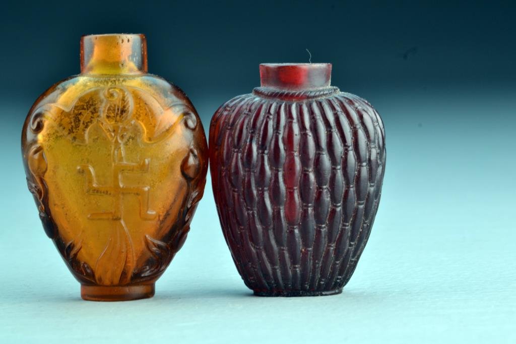 (2) Chinese Peking Glass Snuff Bottles: One finely molded to resemble weaving, the other molded to depict peaches and bat with swastika, tallest is 2.9"H. From the collection of David Bell who worked for an Italian steel company in China du