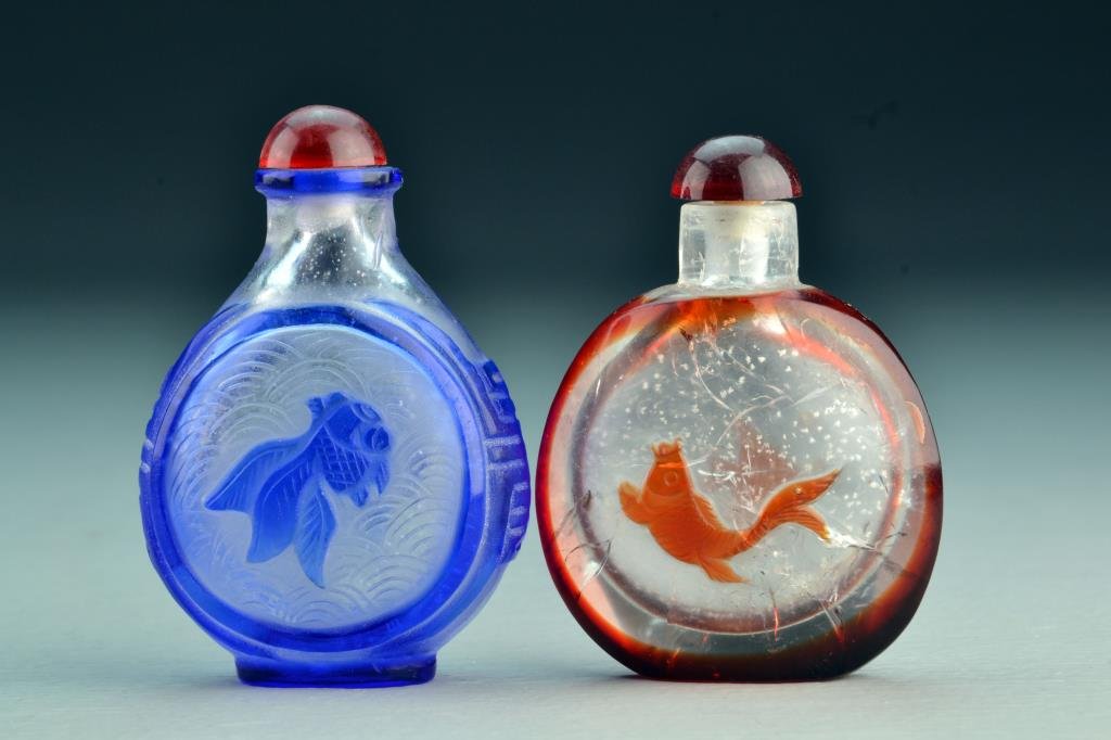 (2) Chinese Peking Glass Snuff Bottles: Each having overlay depicting fish at center, one having symbol on sides and incised wave design, tallest is 3.2"H. From the collection of David Bell who worked for an Italian steel company in China d