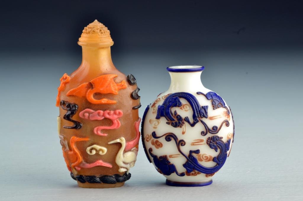 (2) Chinese Peking Glass Snuff Bottles: Each having multi-colored overlay, one depicting bats and chi long among ruyi clouds, other depicting cranes among ruyi clouds, tallest is 3.5"H. From the collection of David Bell who worked for an It