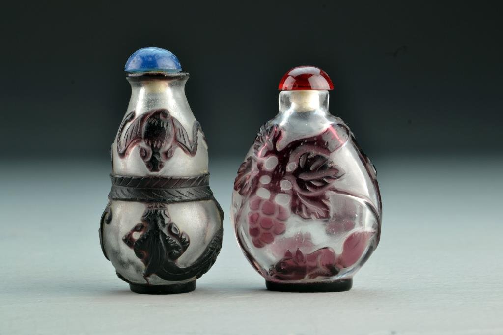(2) Chinese Peking Glass Snuff Bottles: One having gourd form with overlay depicting bats and chi long, other depicting grapes and squirrel, tallest is 2.9"H. From the collection of David Bell who worked for an Italian steel company in Chin
