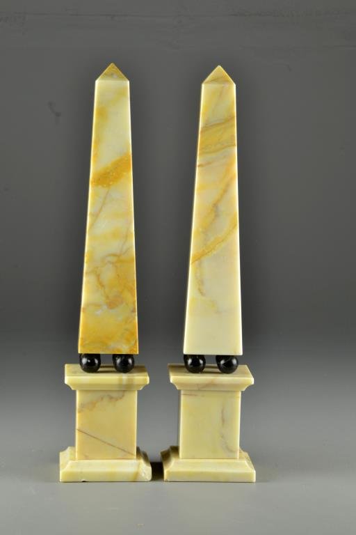 (Pr) Carved Marble Obelisks: To include two obelisks each raised on four black stone spheres atop marble bases, each measures 16.6"H, circa 20th century.