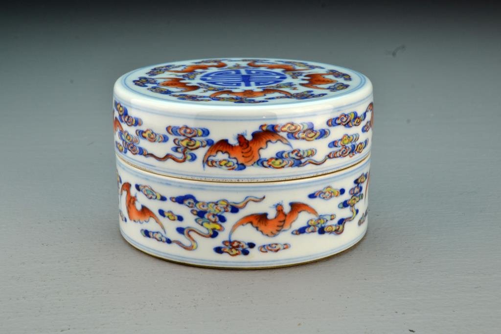 Chinese Blue, White & Iron Red Porcelain Covered Box: Finely painted with a central Shou symbol surrounded by iron red bats and ruyi clouds, base with seal mark in underglaze blue, 2.75"H X 4.5"D.