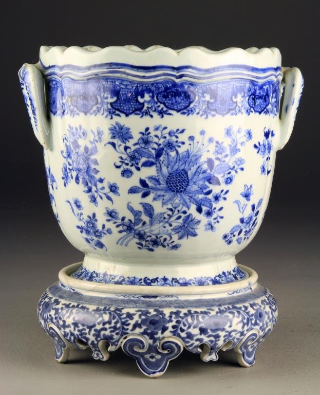 Chinese Qing Blue & White Porcelain Flower Pot & Stand: Finely painted to depict lotus blossoms and tendrils, with two shaped handles, raised on associated blue & white porcelain stand, flower pot circa 19th century, stand 18th century. Condition: with rou