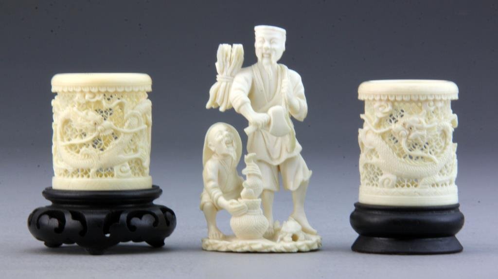 (3) Pcs Chinese Carved Ivory: To include two napkin rings carved to depict dragons with intricate lacework background each having a hardwood base and a carving of two figures with fish and a crab, largest measures 3.75"H, circa 20