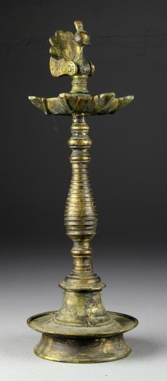 An Indian Bronze Wedding Grease Lamp: Having a dish form base, turned central shaft with stylized bird finial, 15.5" H circa 19th Century. Collection of the Late Robert Willis owner of R.F. Willis Galleries, Grand Rapids, Michigan.