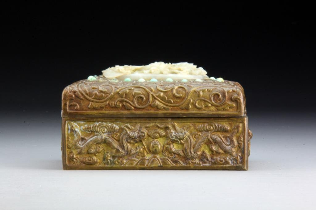 Chinese Copper Box Inlaid with Jade Plaque: The box molded to depict lotus blossoms and tendrils and set with carved jade plaque depicting cranes and lotus, 5.75" L x 3.5" H, circa late 19th-early 20th century.