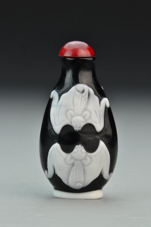 Chinese Peking Glass Snuff Bottle: Finely molded to depict bats, raised on a short foot, complete with stopper, 2.75"H. From the collection of David Bell who worked for an Italian steel company in China during the 1980's.