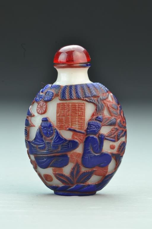 Chinese Peking Glass Snuff Bottle: Dual-colored overlay depicting figures beneath ancient trees, having seal on reverse, complete with stopper, 3"H. From the collection of David Bell who worked for an Italian steel company in China dur