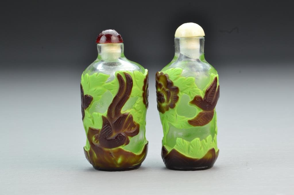 (2) Chinese Peking Glass Snuff Bottles: Clear glass with brown and green overlay depicting birds among flowers, complete with stoppers, tallest is 2.875"H. From the collection of David Bell who worked for an Italian steel company in China d