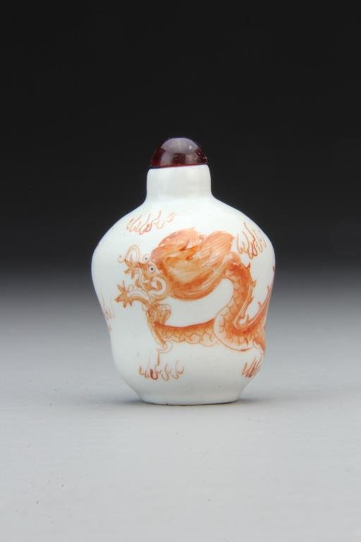 Chinese Porcelain Snuff Bottle: Finely painted in iron red to depict four clawed dragon chasing flaming pearl, complete with stopper, 2.5"H. From the collection of David Bell who worked for an Italian steel company in China during t