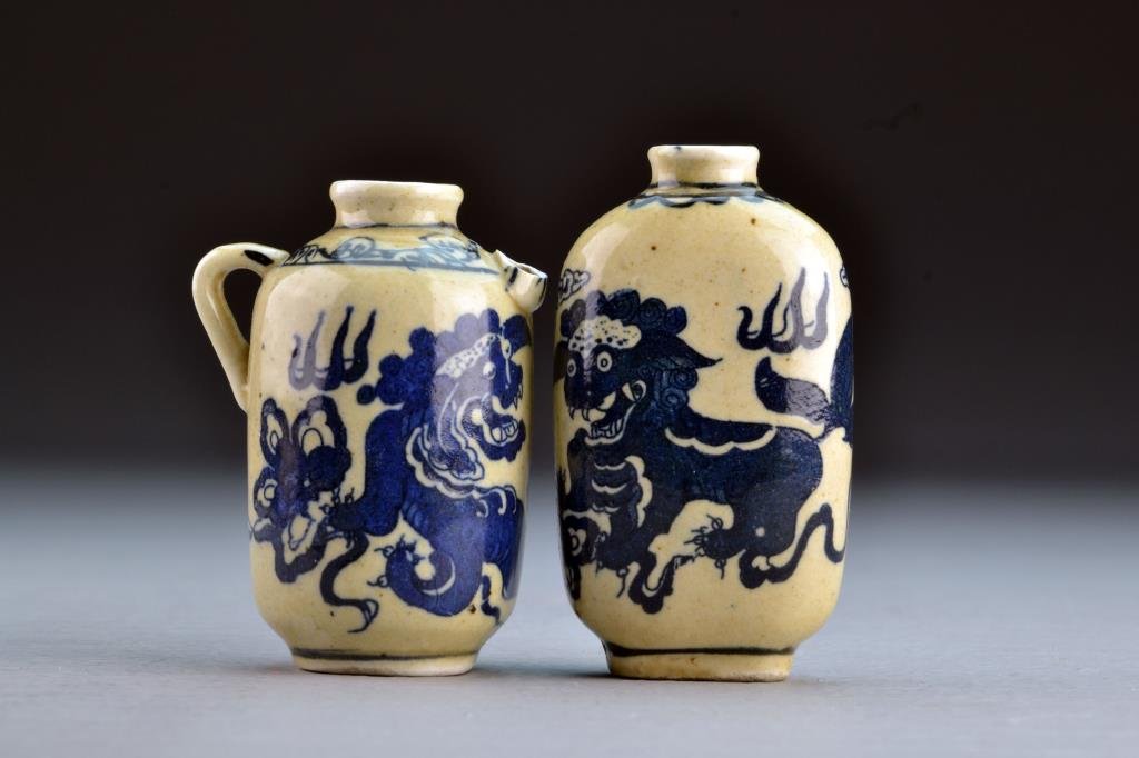 (2) Chinese Blue and White Porcelain Snuff Bottles: Having unique depiction of foo dogs among ruyi clouds, one base bearing four character mark, the other marked by leaf in underglaze blue, spout broken on pitcher, tallest is 2.9"H. From the collection
