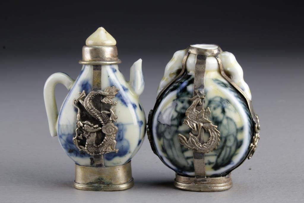 (2) Chinese Porcelain Snuff Bottles: Both having metal fixtures depicting phoenix and four clawed dragons, one having beast head handles, bases bearing character marks, one having seal, tallest is 2.4"H. From the collection of David Bell