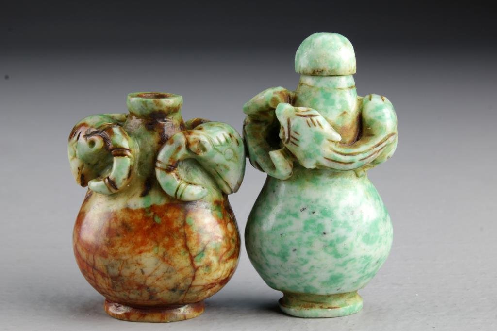 (2) Chinese Carved Jadeite Snuff Bottles: Two finely carved jadeite examples, one with ram heads at neck, the other having a chi long wrapped around bottle, tallest is 2.5"H. From the collection of David Bell who worked for an Italian steel c