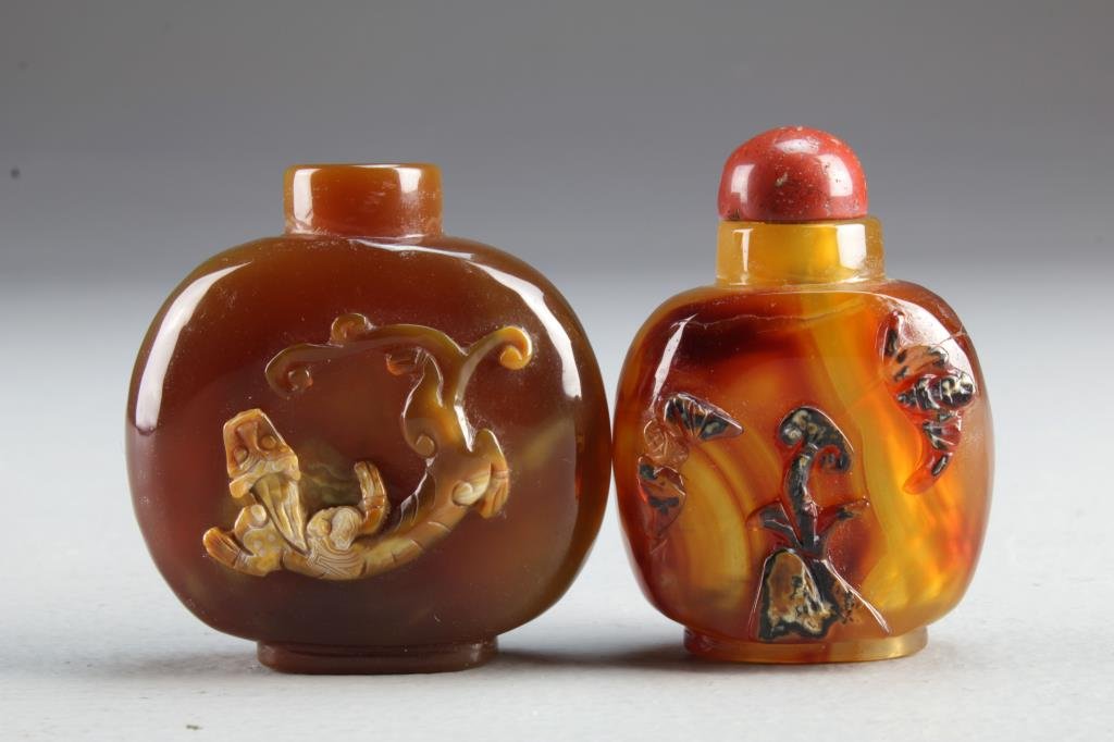(2) Chinese Carved Agate Snuff Bottles: One carved to depict a chi long, the other depicting bats with a flower at center, tallest is 2.25"H.