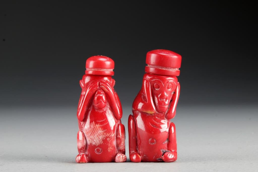 (2) Chinese Carved Coral Snuff Bottles: Finely carved coral bottles in form of "hear no evil "and "see no evil" monkeys, having smooth polished surface, complete with matching coral stoppers and metal spoons, good condition, tallest is 2.5"