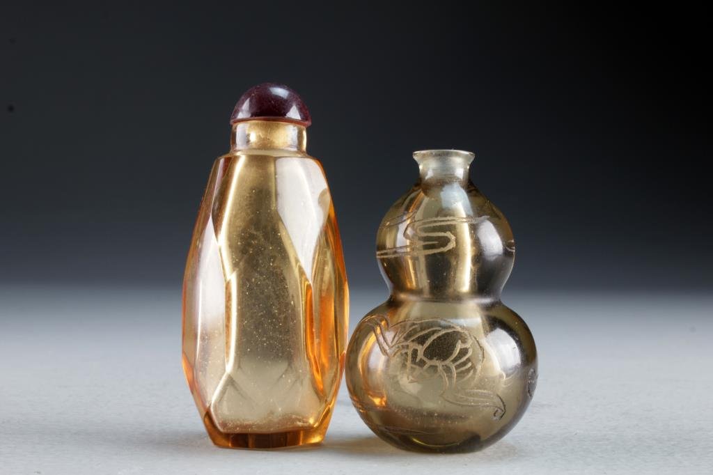 (2) Chinese Peking Glass Snuff Bottles: Two finely molded examples having clear glass, one formed as gourd and carved with depiction of bats and ruyi clouds, the other a geometric example having a hexagon base, tallest is 3.1"H.