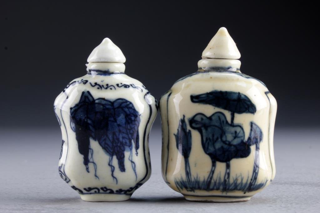 (2) Chinese Blue and White Porcelain Snuff Bottles: One finely painted at center to depict lotus flowers, the other depicting bunches of grapes and a cricket on reverse side, bases marked by leaf in underglaze blue, tallest is 2.5"H.